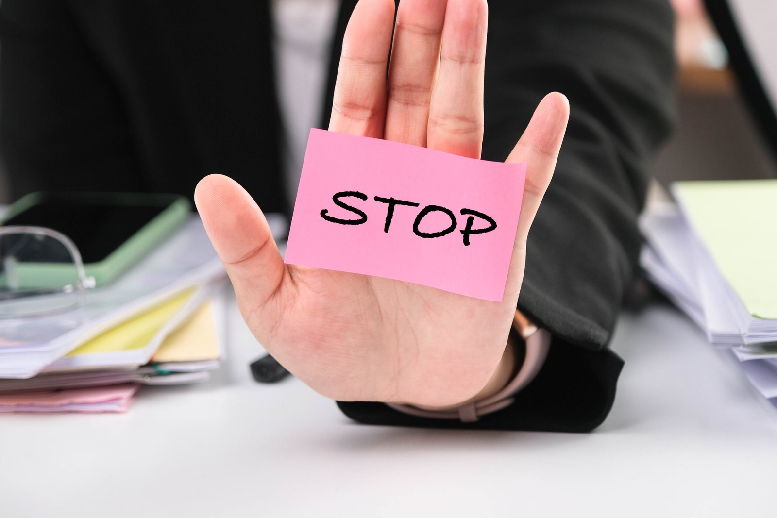 Close-up of a business woman showing a stop gesture with the ins Close-up of a business woman showing a stop gesture with the inscription "Stop" on her palm. Stop corruption concept.